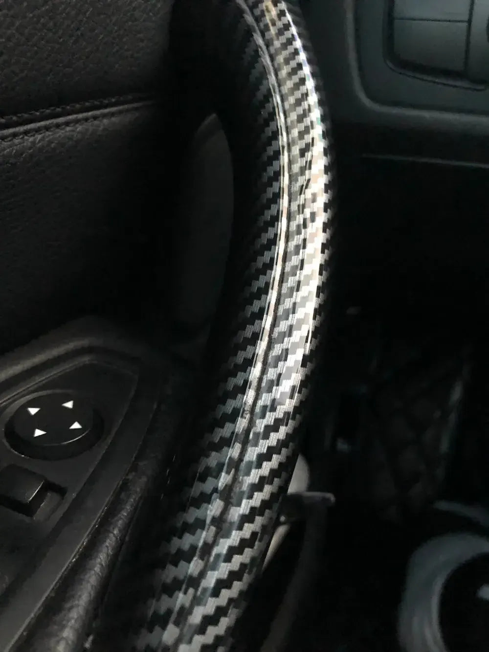 Felszerelt carbon belső kilincs borítás közelről, mellette az ablakemelő kapcsoló – BMW F30