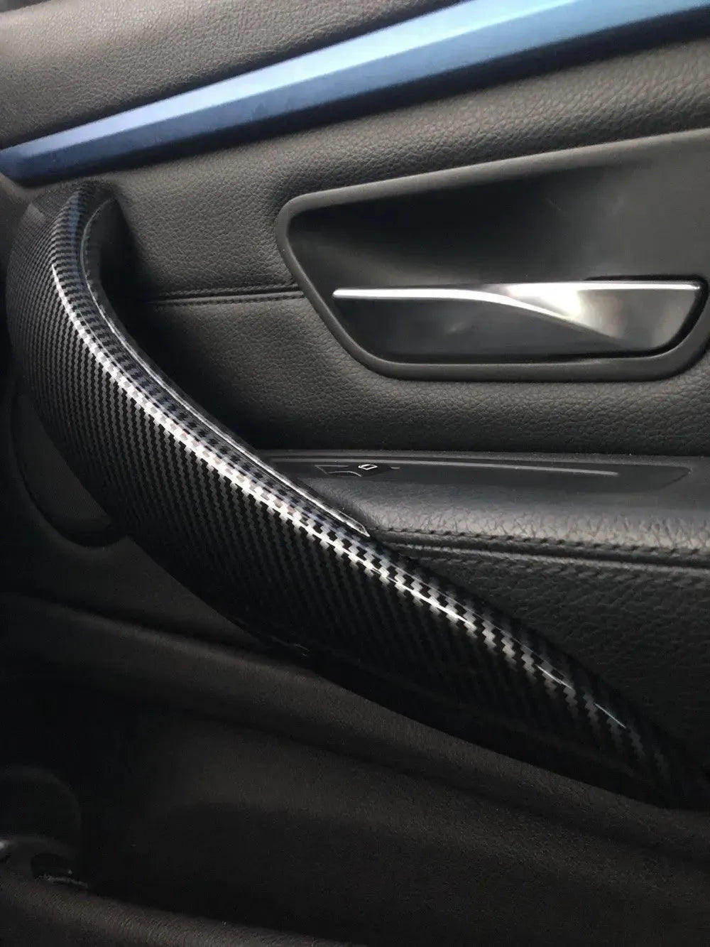 Carbon belső kilincs borítás BMW F30 ajtón, ferde szögből fotózva