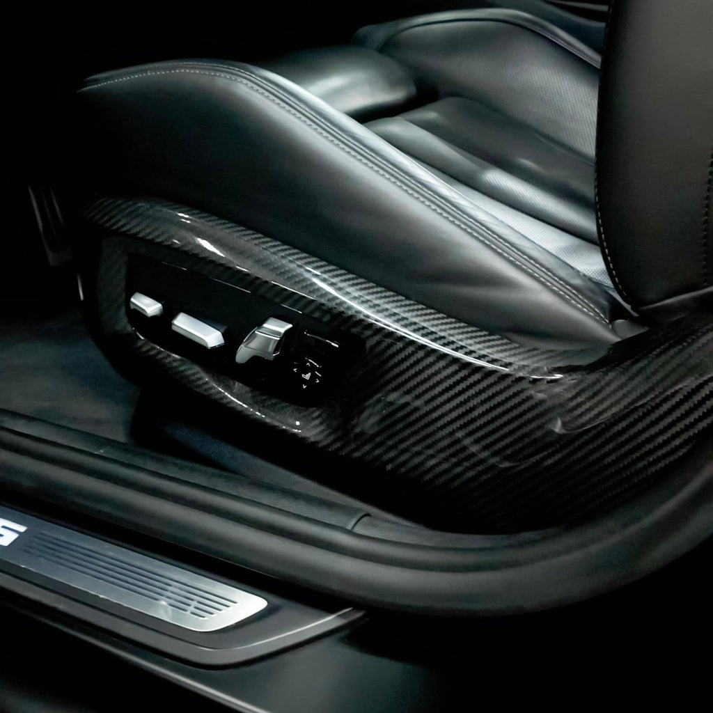 BMW F90 M5 black leather sport seat: carbon side cover around the seat adjustment switches, with M5 door sill