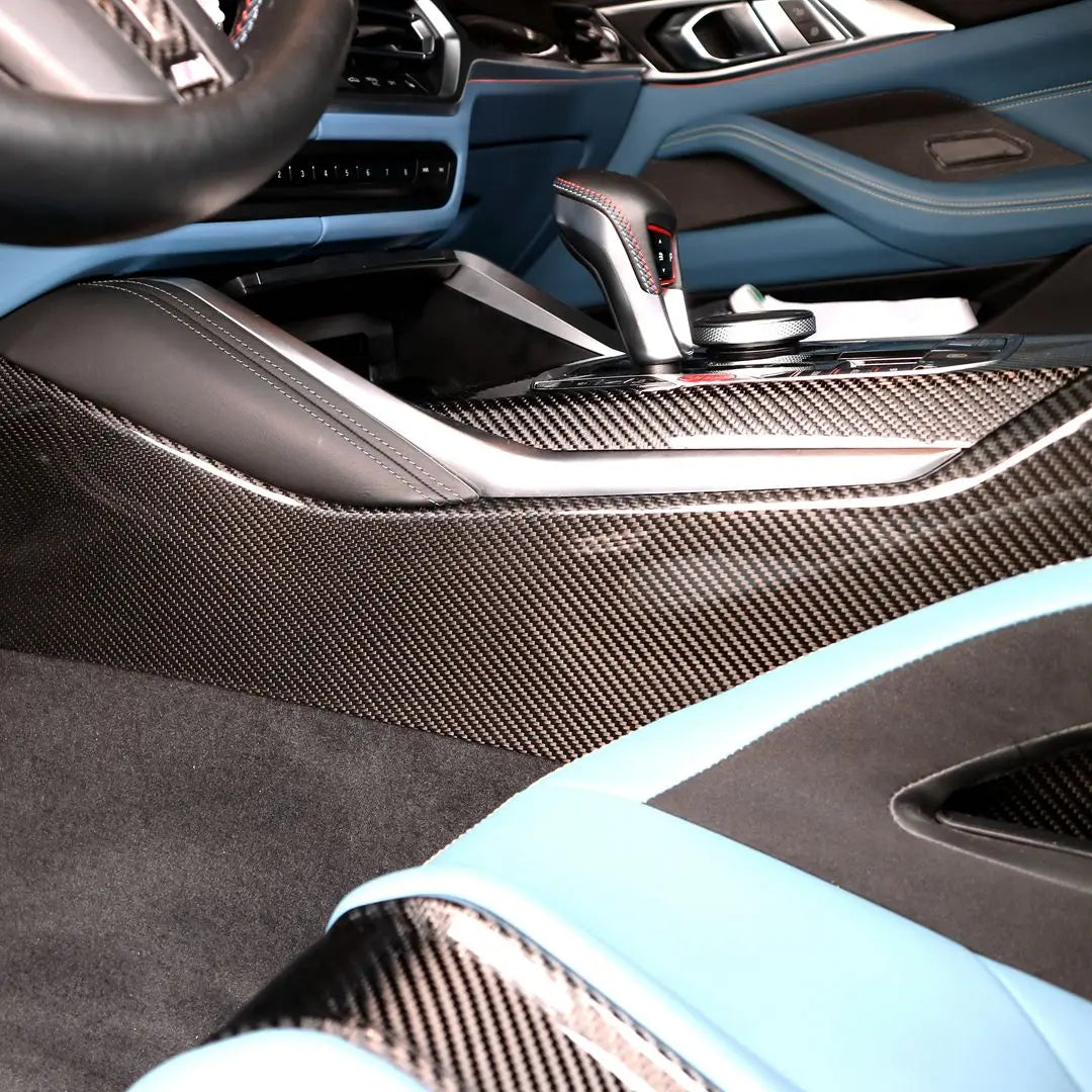 Carbon fiber center console trim with sleek woven texture and metallic accents for bmw m3 kipufogó system interior elements