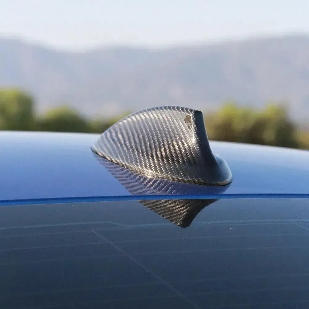 Carbon tetőantenna borítás kék BMW tetején hátulról, háttérben hegyekkel