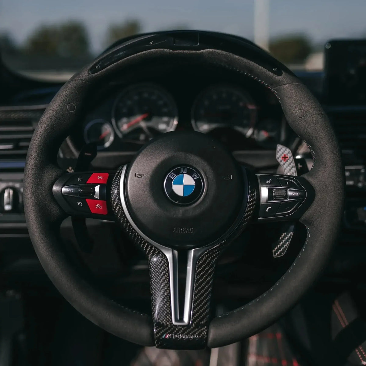 Egyedi Alcantara kormány carbon felső résszel és piros gombokkal, szemből – BMW F széria