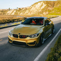 Carbon body kit on a yellow BMW F82 M4, front view on the road (Laptor + PSM Style)