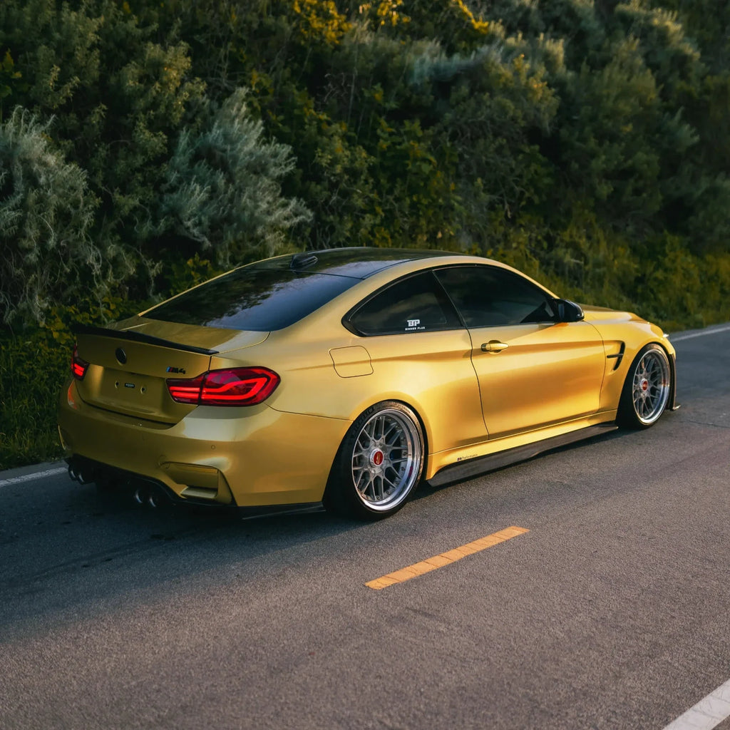 Carbon body kit on a yellow BMW F82 M4, rear three-quarter side view (Laptor + PSM Style)