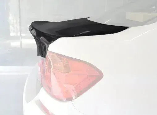 Rear corner of a white BMW F80 M3, close-up, showing the ducktail edge of the carbon trunk lid (CSL Style)