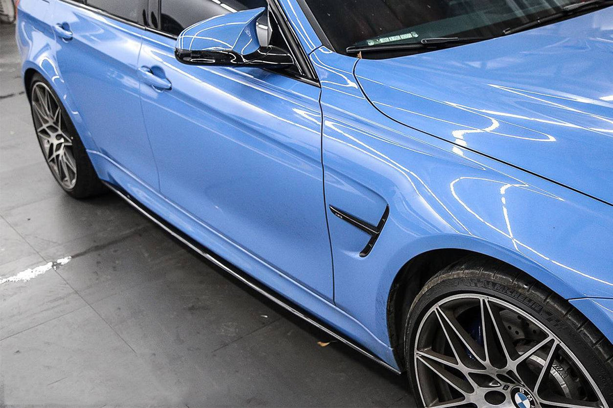 Side of a blue BMW F80 M3 sedan, close-up, with fitted carbon side skirt (MP Style)