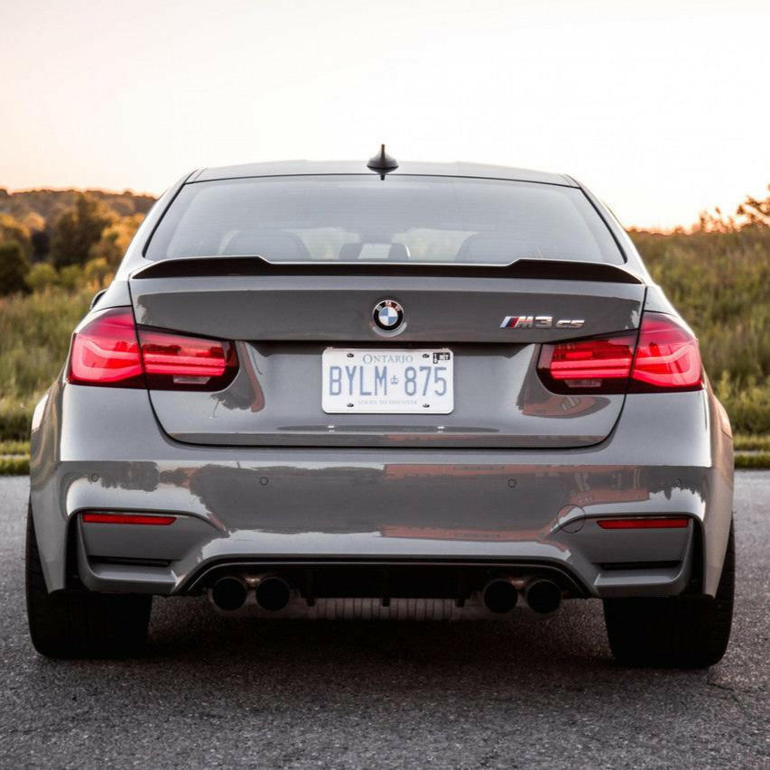 Szürke BMW F80 M3 hátulnézetből a szabadban, carbon csomagtartó spoilerrel (CS Style)