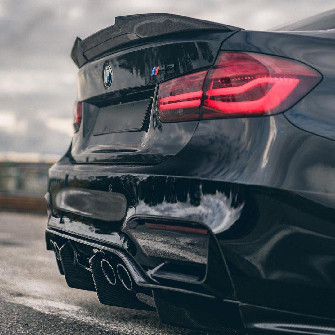 Fekete BMW F80 M3 alacsony, ferde hátulnézetben, carbon csomagtartó spoilerrel (Ducktail Style)