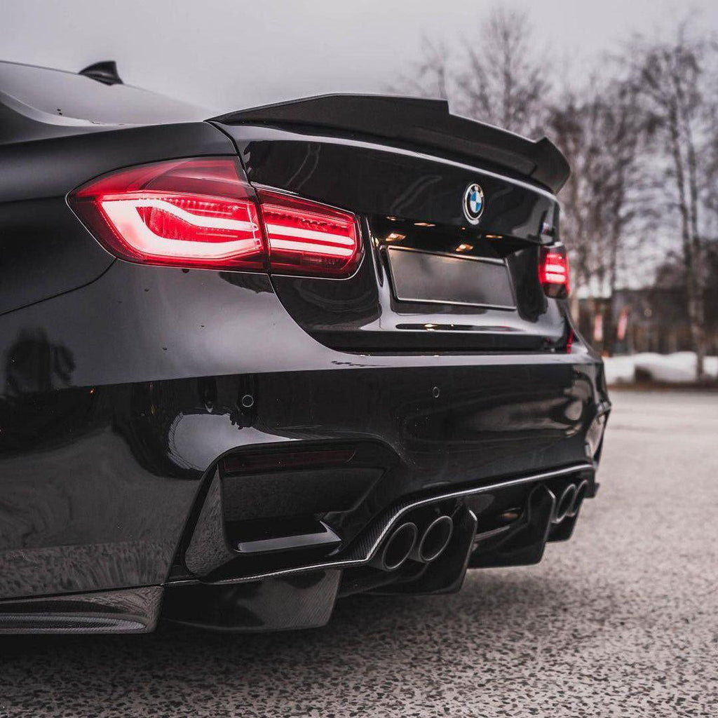 Fekete BMW F80 M3 ferdén hátulról, felszerelt carbon spoilerrel (Ducktail Style)
