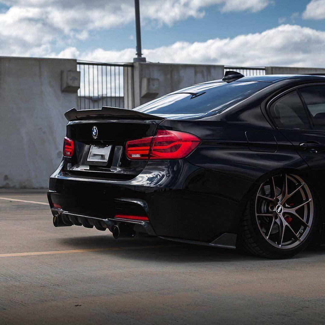 Fekete BMW F30 ferdén hátulról a parkolószinten, carbon csomagtartó spoilerrel (Ducktail Style)