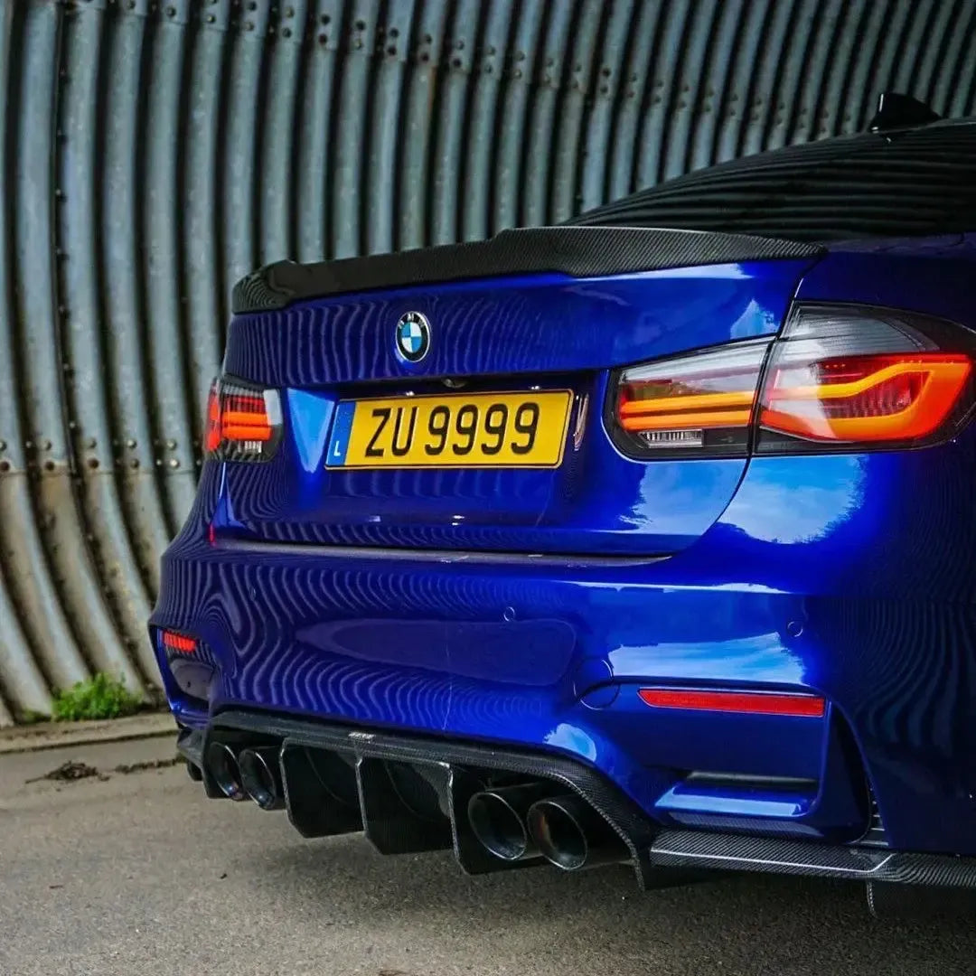 Kék BMW F80 M3 ferdén hátulról, felszerelt carbon csomagtartó spoilerrel (M4 Style)