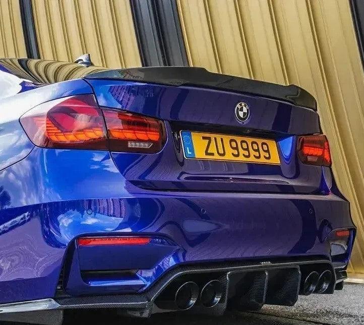 Kék BMW F80 M3 hátsó része közelről, ferde nézetben, carbon spoilerrel (M4 Style)