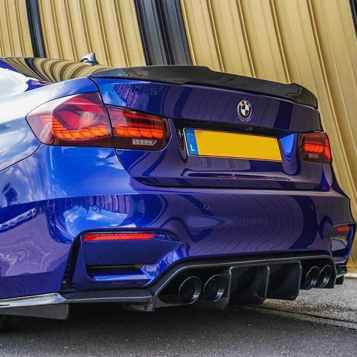Kék BMW F80 M3 csomagtartója közelről, ferdén hátulról, carbon spoilerrel (PM V1 Style)