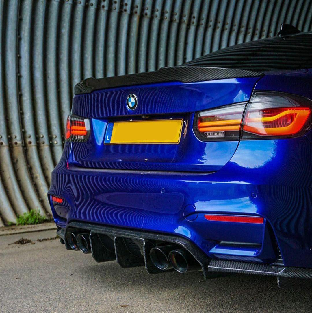 Kék BMW F80 M3 ferdén hátulról, felszerelt carbon csomagtartó spoilerrel (PM V1 Style)