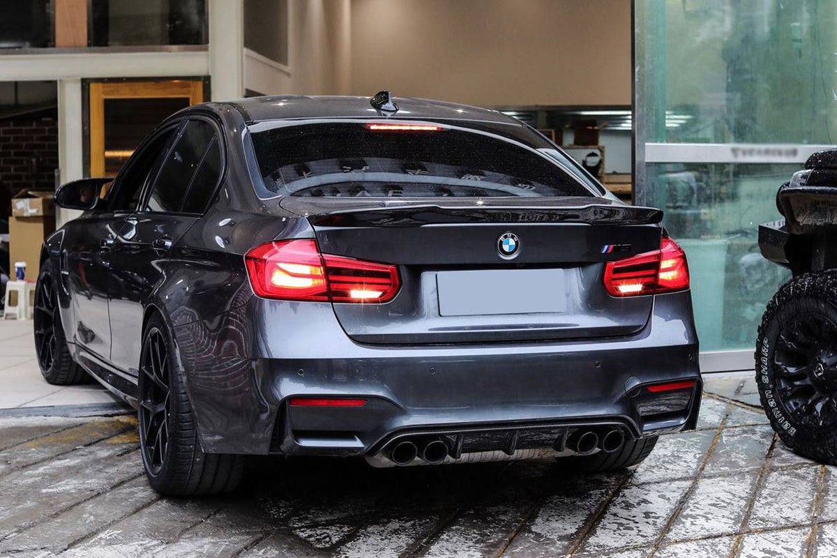Szürke BMW F80 M3 ferdén hátulról a műhelyben, carbon csomagtartó spoilerrel (VRS Style)