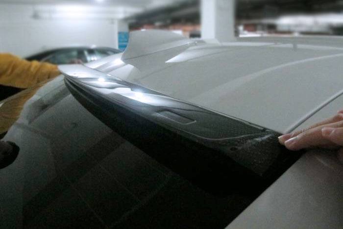 Carbon tetőspoiler próbaillesztése ezüst BMW F30 hátsó szélvédőjén, kézzel tartva (MP Style)