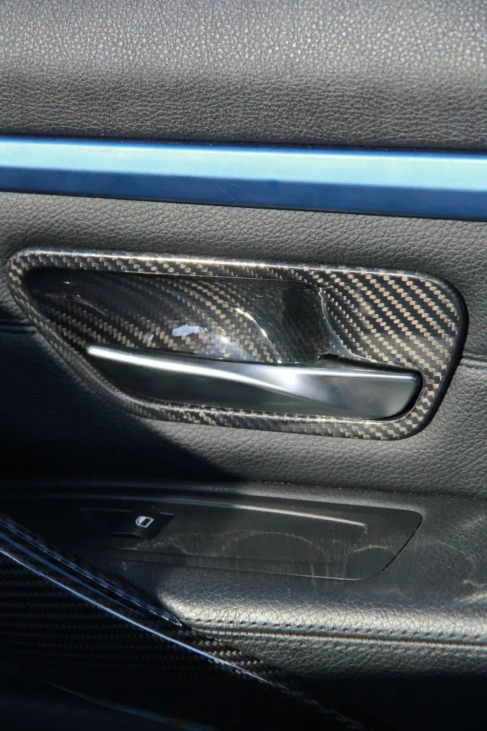 Beszerelt carbon belső kilincs mélyedés borítás BMW M3/M4 ajtókárpiton, közeli kép
