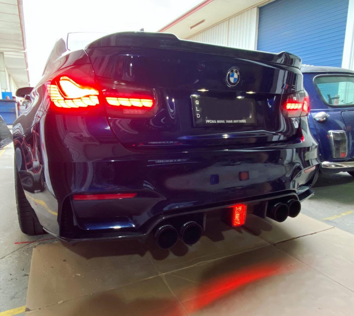 Dark blue BMW F80 M3 from the rear, carbon diffuser with LED brake light, red light lit (K Style)
