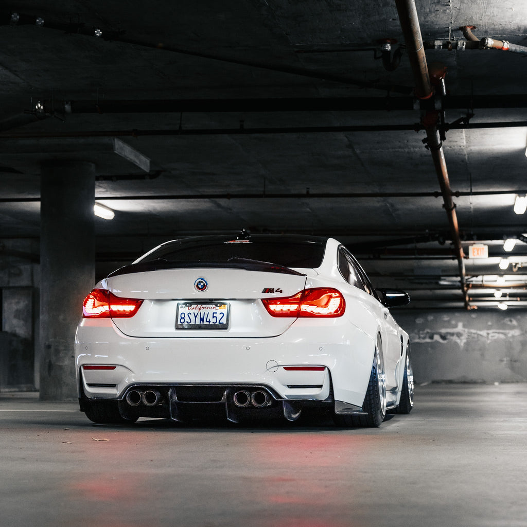 Fehér BMW F82 M4 hátulnézetből a parkolóházban, carbon diffúzorral (PSM Style)