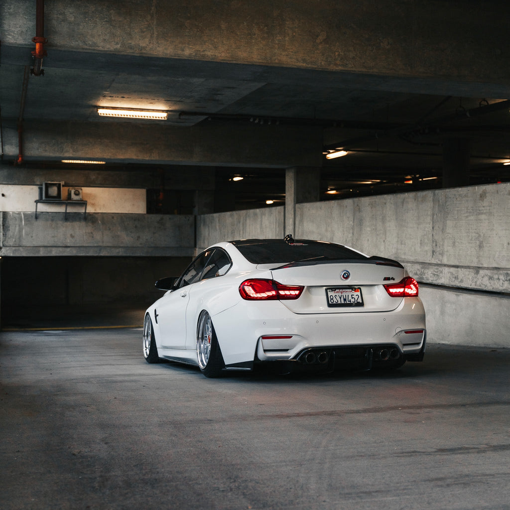 Fehér BMW F82 M4 távolról, parkolóházban, LED féklámpás carbon hátsó diffúzorral (PSM Style)