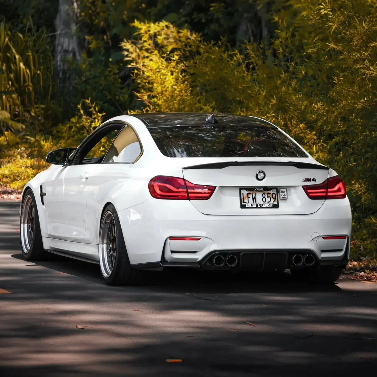 Fehér BMW F82 M4 hátsó háromnegyed nézetben az úton, carbon diffúzorral (V Style)