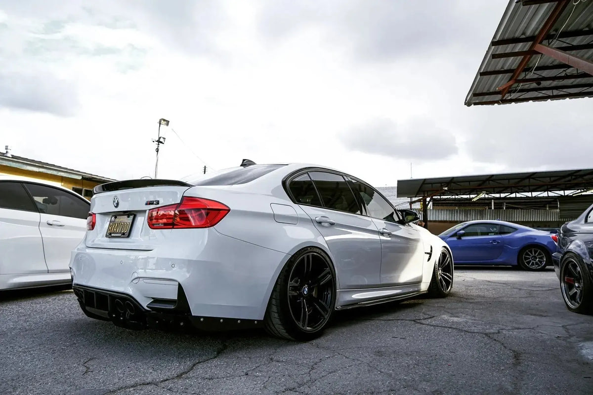 White BMW F80 M3 in rear three-quarter view in a parking lot, with rear diffuser (VRS Style)
