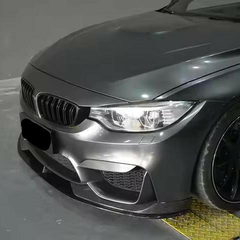 Gray BMW F82 M4 front corner in the workshop, with two-layer carbon front lip (AC Style)