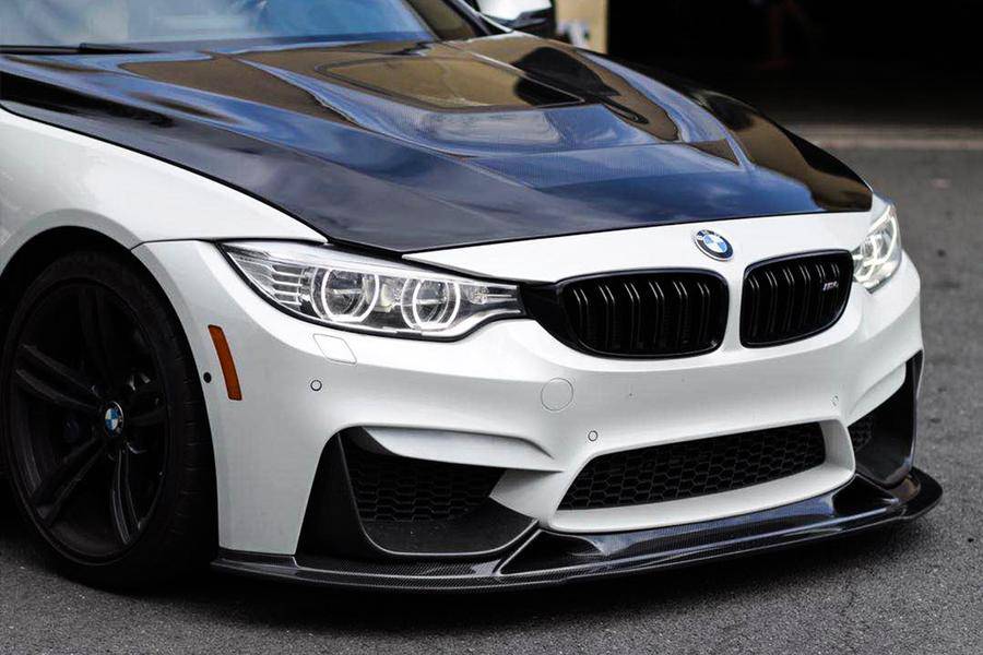 White BMW F82 M4 from a front angle, with carbon hood and carbon front lip (BS Style)