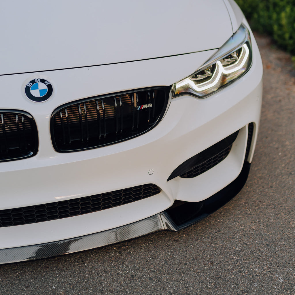 White BMW F82 M4 front corner close-up, with carbon front lip (CS Style)