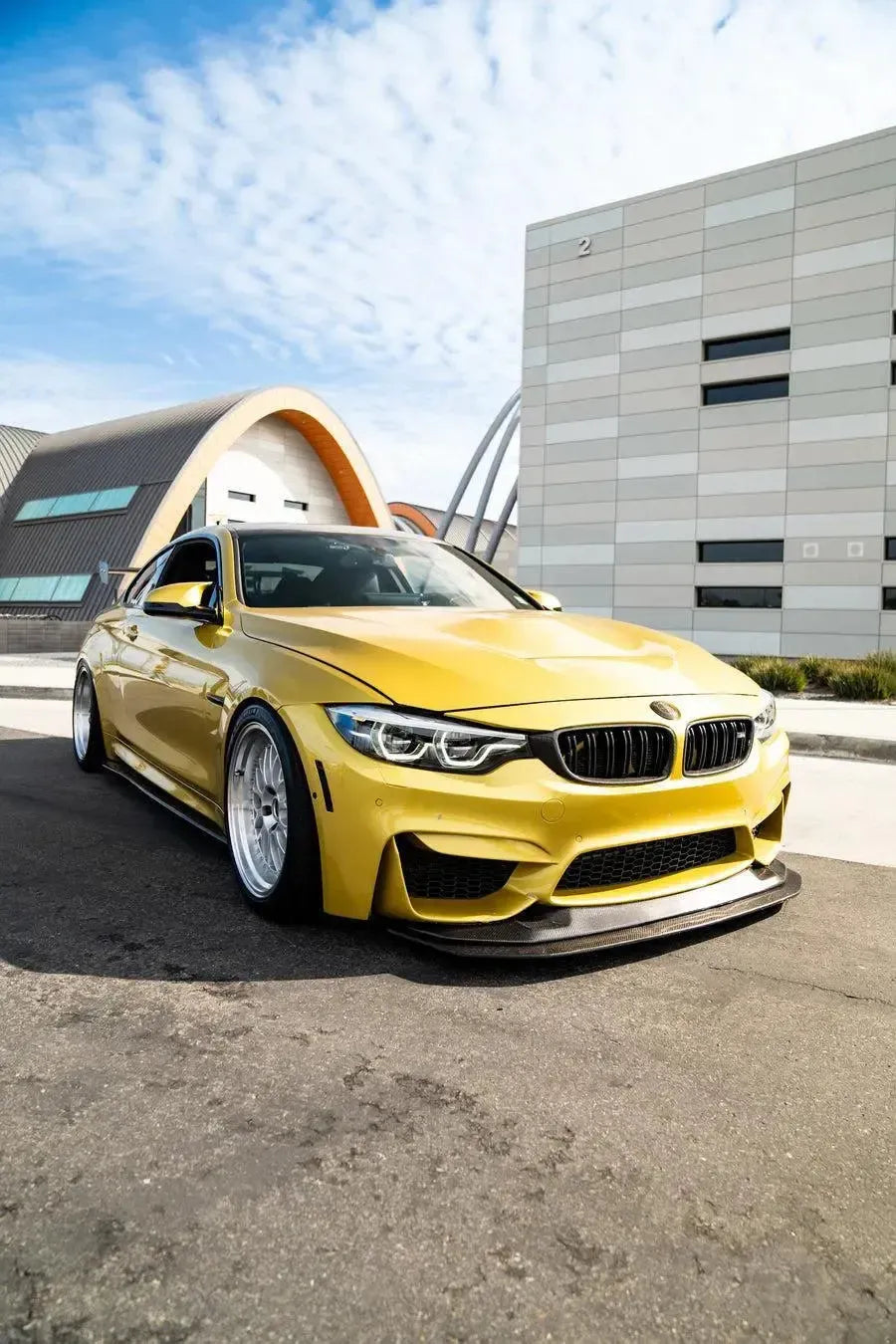 Carbon fiber front lip (GTS Style) on a yellow BMW F82 M4, angled front view
