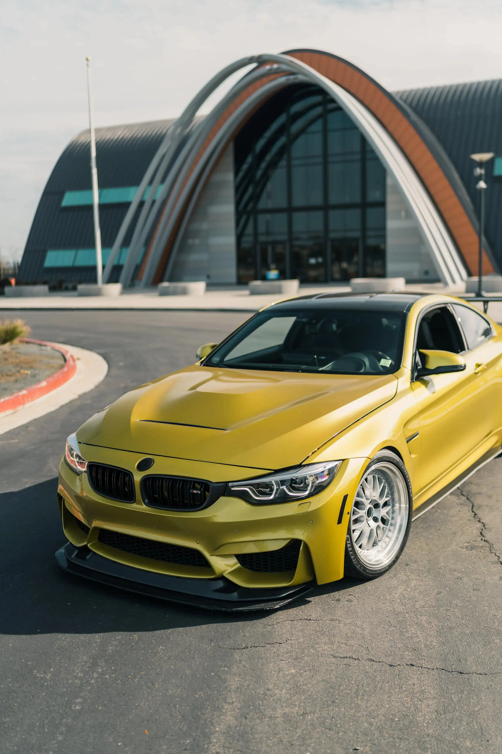 Yellow BMW F82 M4 three-quarter front view, fitted carbon lip (GTS Style)