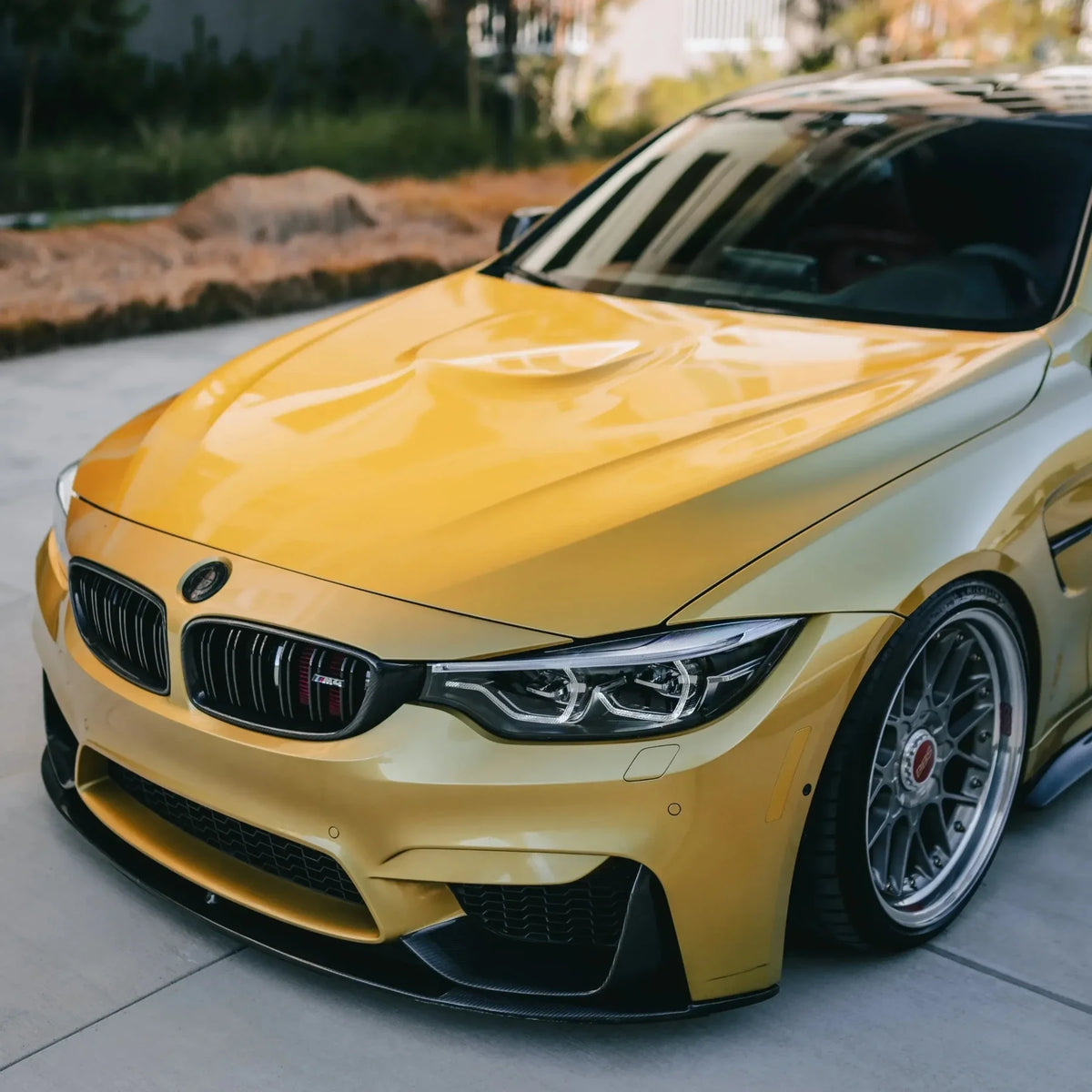 Carbon fiber front lip (MP Style) on the front of a yellow BMW F82 M4, three-quarter front view