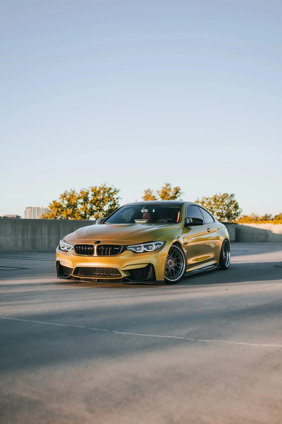 Yellow BMW F82 M4 from further away, angled front, carbon front corner splitters (MP Style)