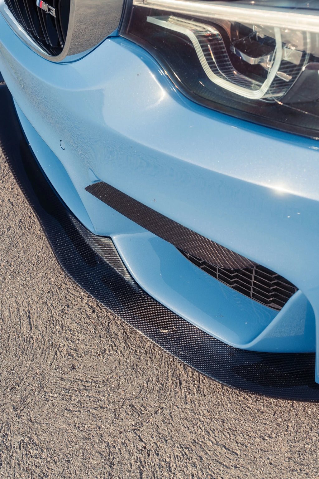 Carbon front lip corner close-up on a blue BMW F80 M3 bumper (PSM Style)