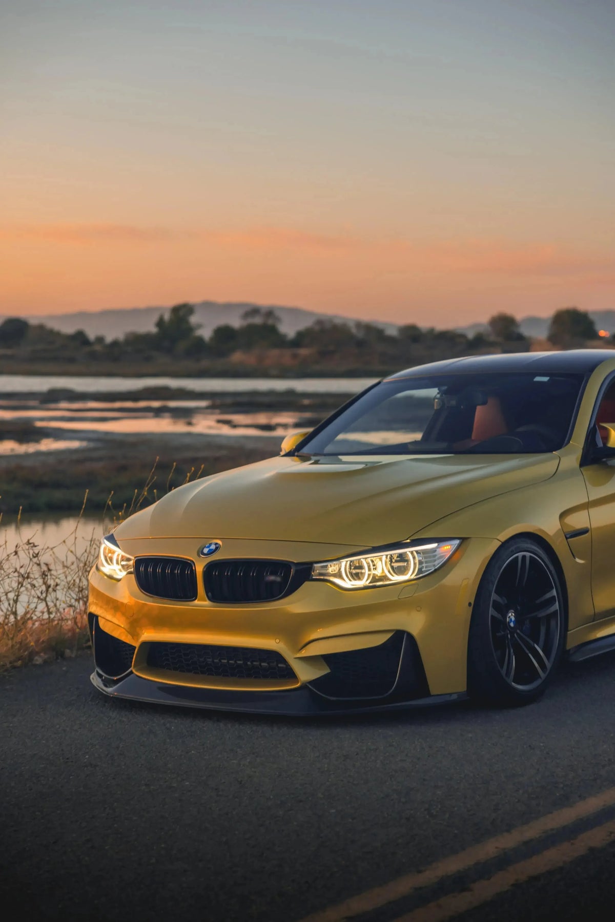 Yellow BMW F82 M4 at sunset, three-quarter front view, carbon front lip (RSC Style)