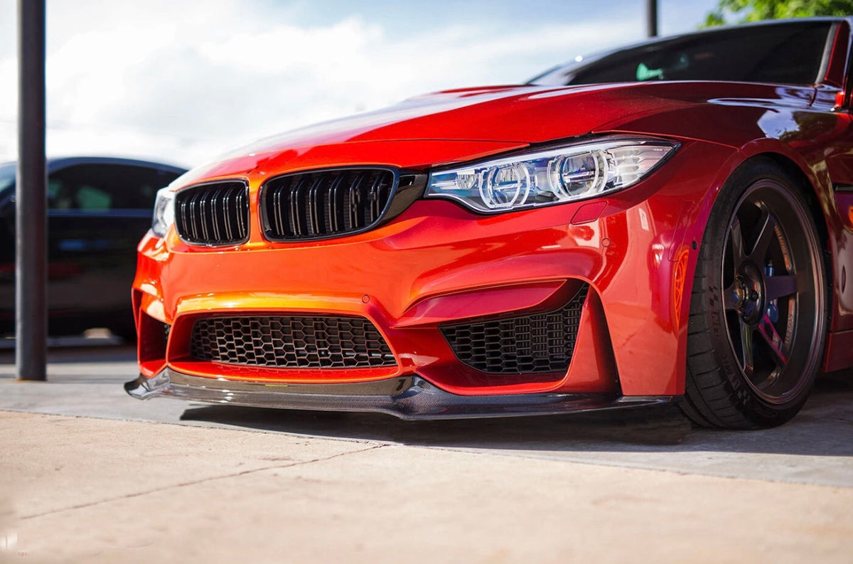 Orange BMW F82 M4 front close-up, angled, with carbon front lip (V Style)