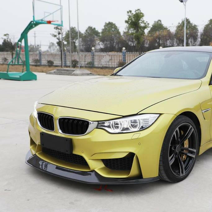 Yellow BMW F82 M4, angled front view, with carbon fiber front lip (V1 Style)