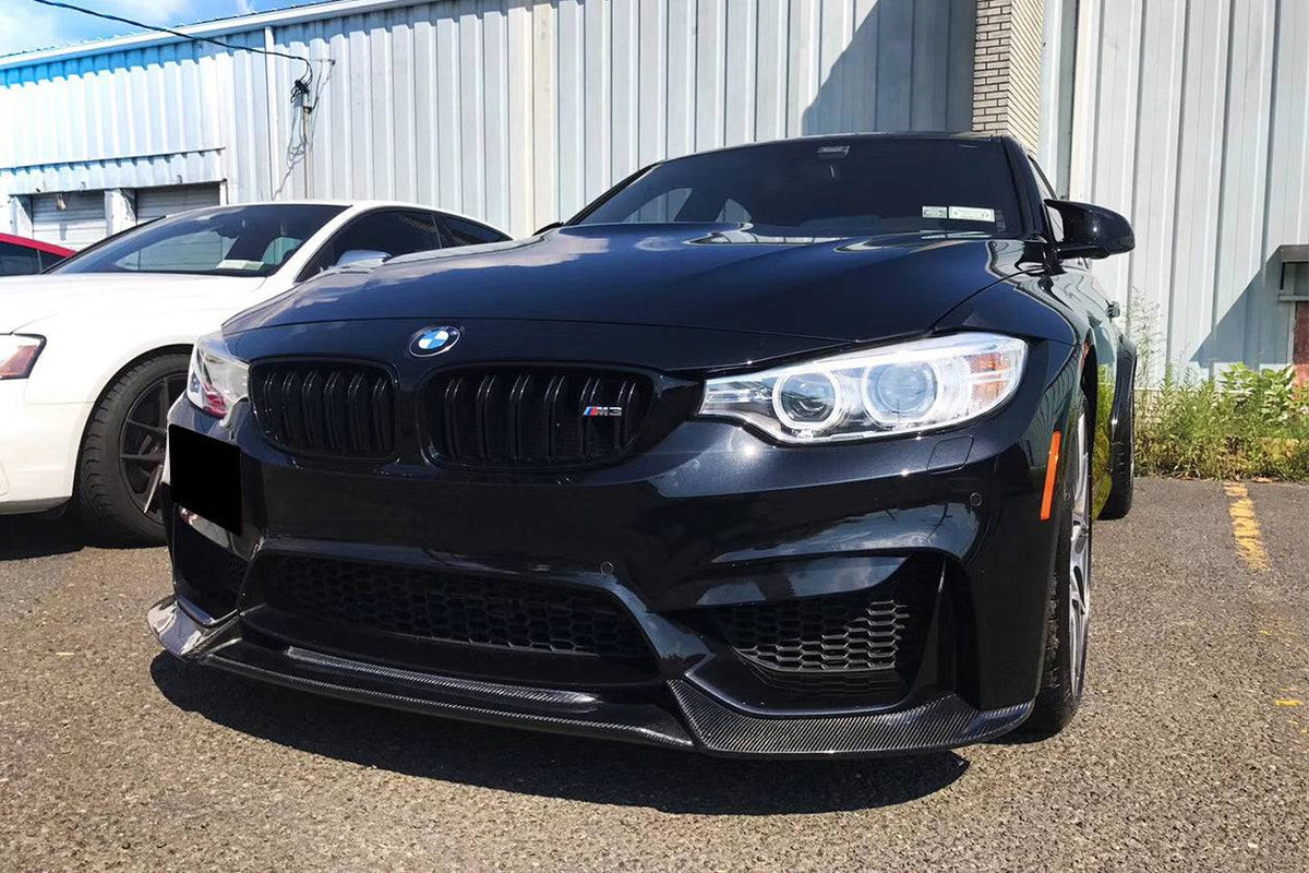 Black BMW F80 M3 in a parking lot, angled front view, with carbon front lip (VA Style)