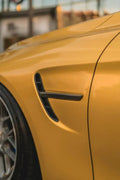 Carbon fender vent trim on the front fender, close-up on a yellow BMW F82 M4