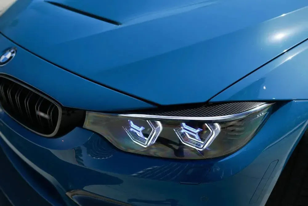 Carbon szemöldök kék BMW M3/M4 fényszóróján, közeli felvétel