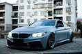 Üvegszálas (FRP) első lökhárító (D3 Style) szürke szélesített BMW F82 M4-en, elölről 3/4-ből