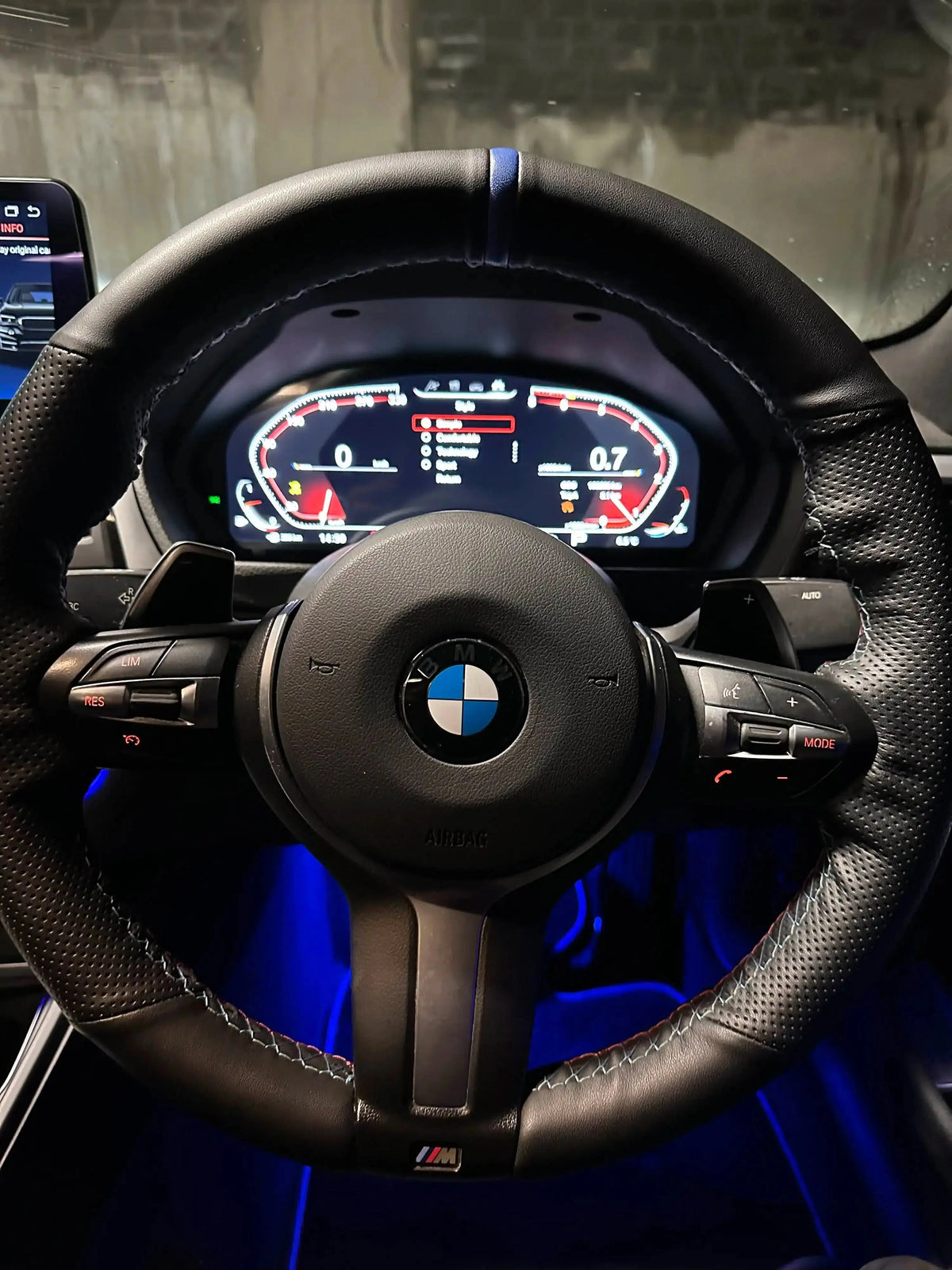 Digital instrument cluster behind the M steering wheel, with blue ambient lighting – BMW F80 M3