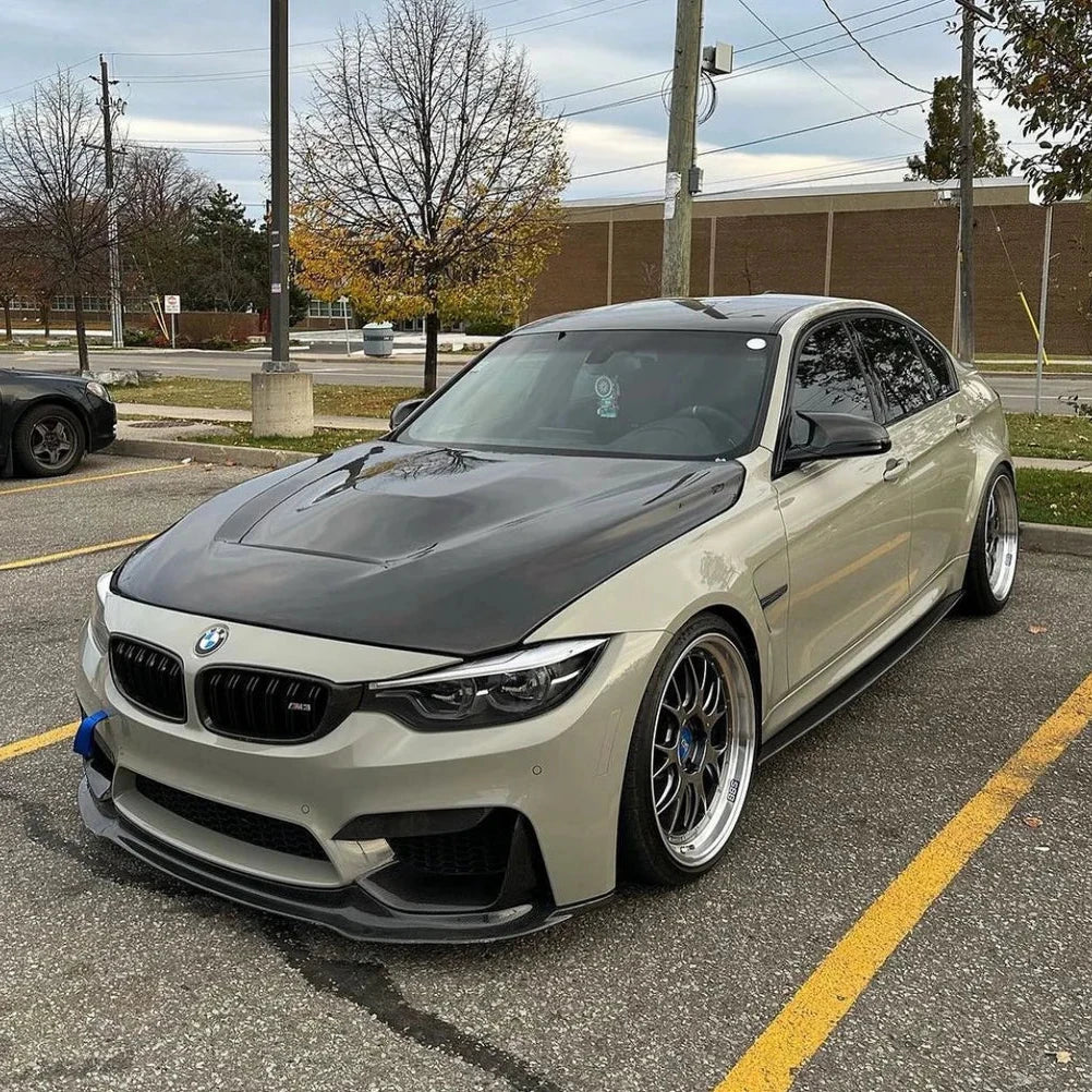Homokszürke BMW F80 M3 elölről ferdén parkolóban, carbon motorháztetővel (GTS Style)