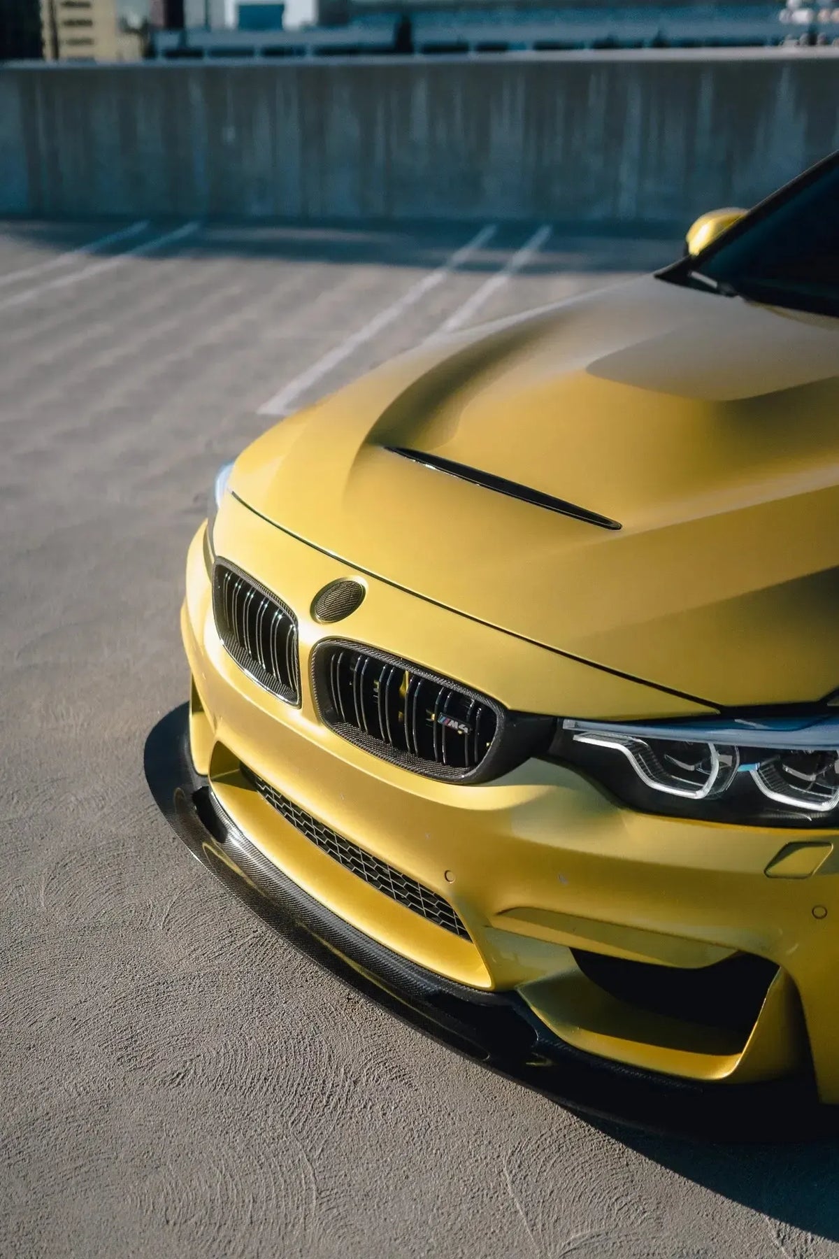 Sárga BMW F82 M4 elölről ferdén, közelről, szellőzős alumínium géptetővel (GTS Style)