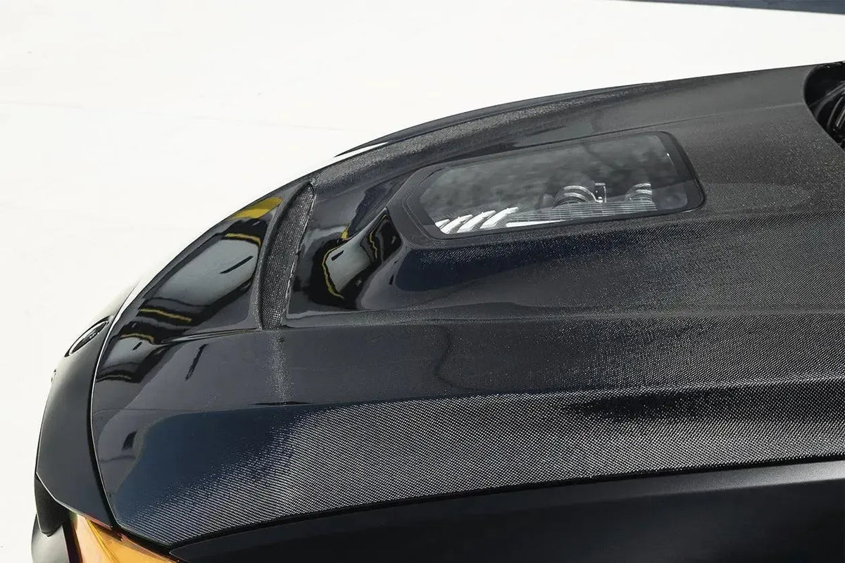 Carbon hood of a BMW M3/M4, close-up, with clear window looking onto the engine (IMP Style)