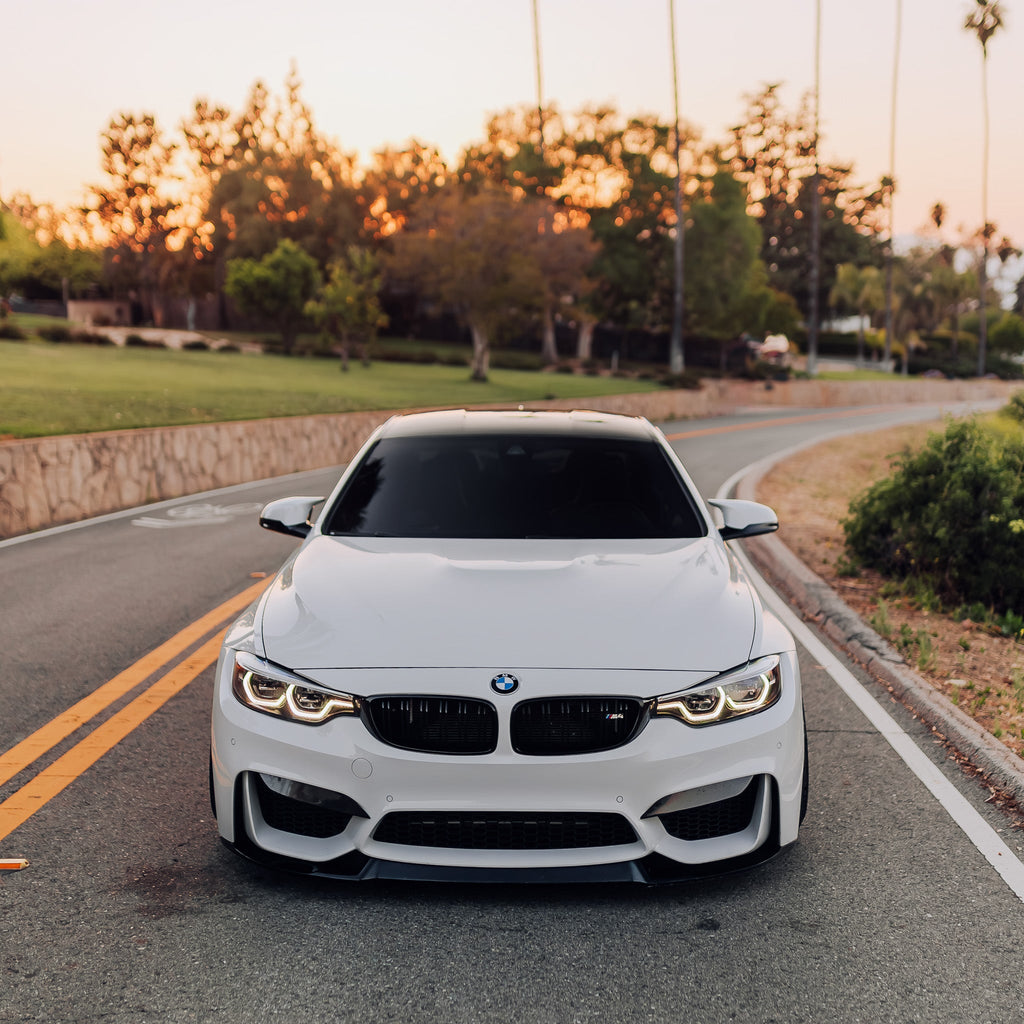 Fehér BMW F82 M4 egyenesen elölről, fényes fekete dupla rácsos vese párral
