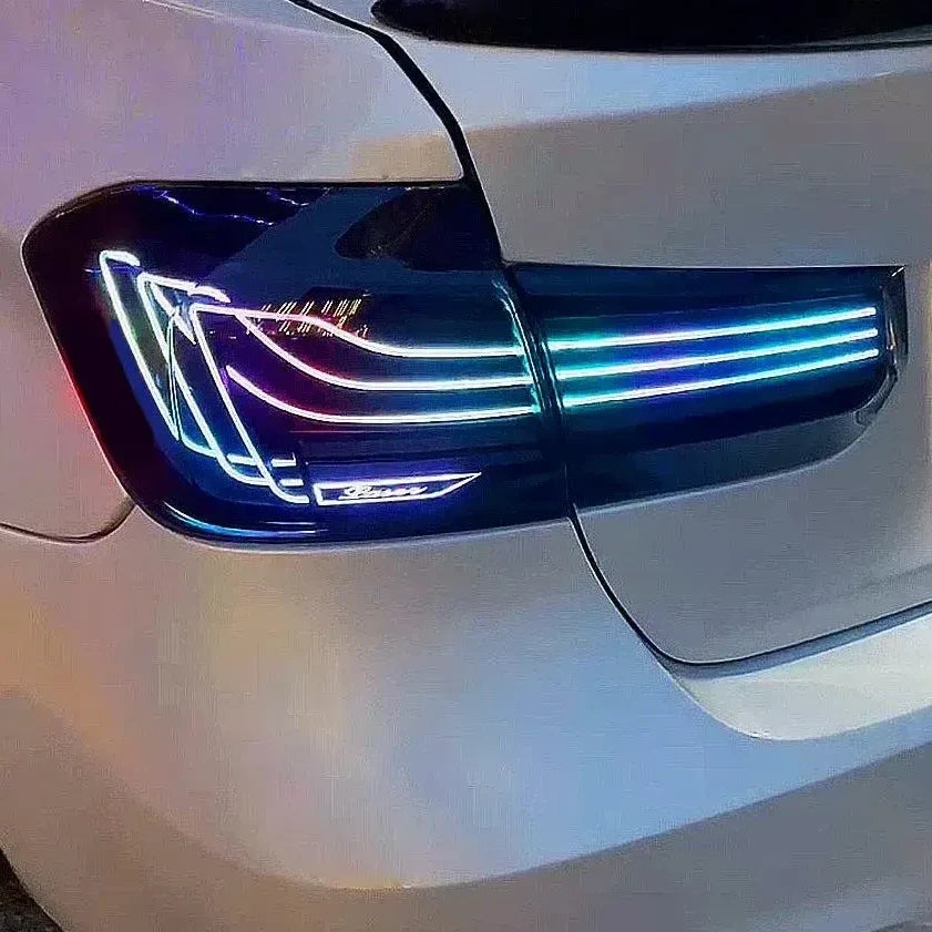 Tail light glowing in RGB colors on the rear corner of a white BMW F30 / F80 M3 (CSL Style)