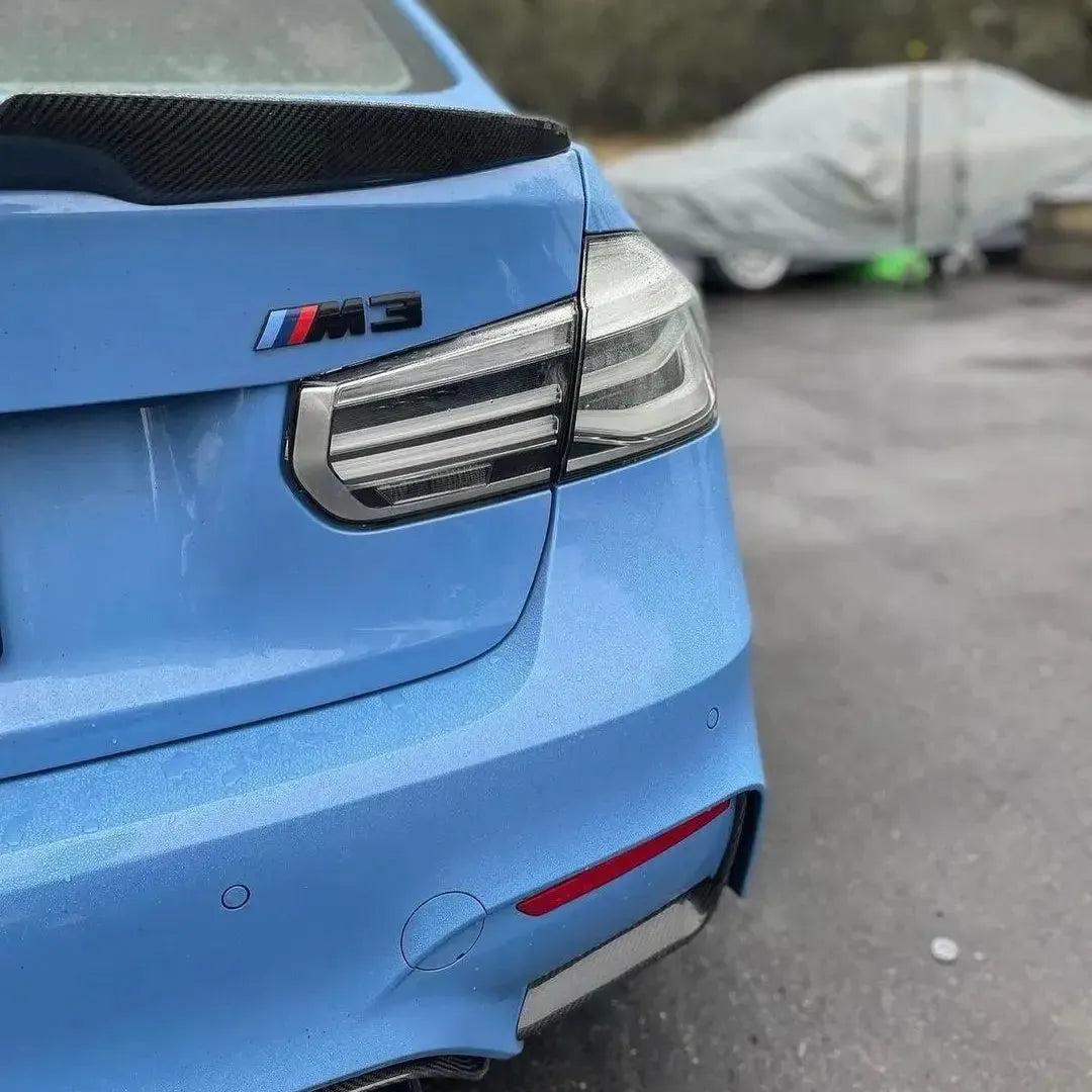 Clear-lens tail light on the rear corner of a blue BMW F80 M3, close-up (Euro Clear LCI Style)