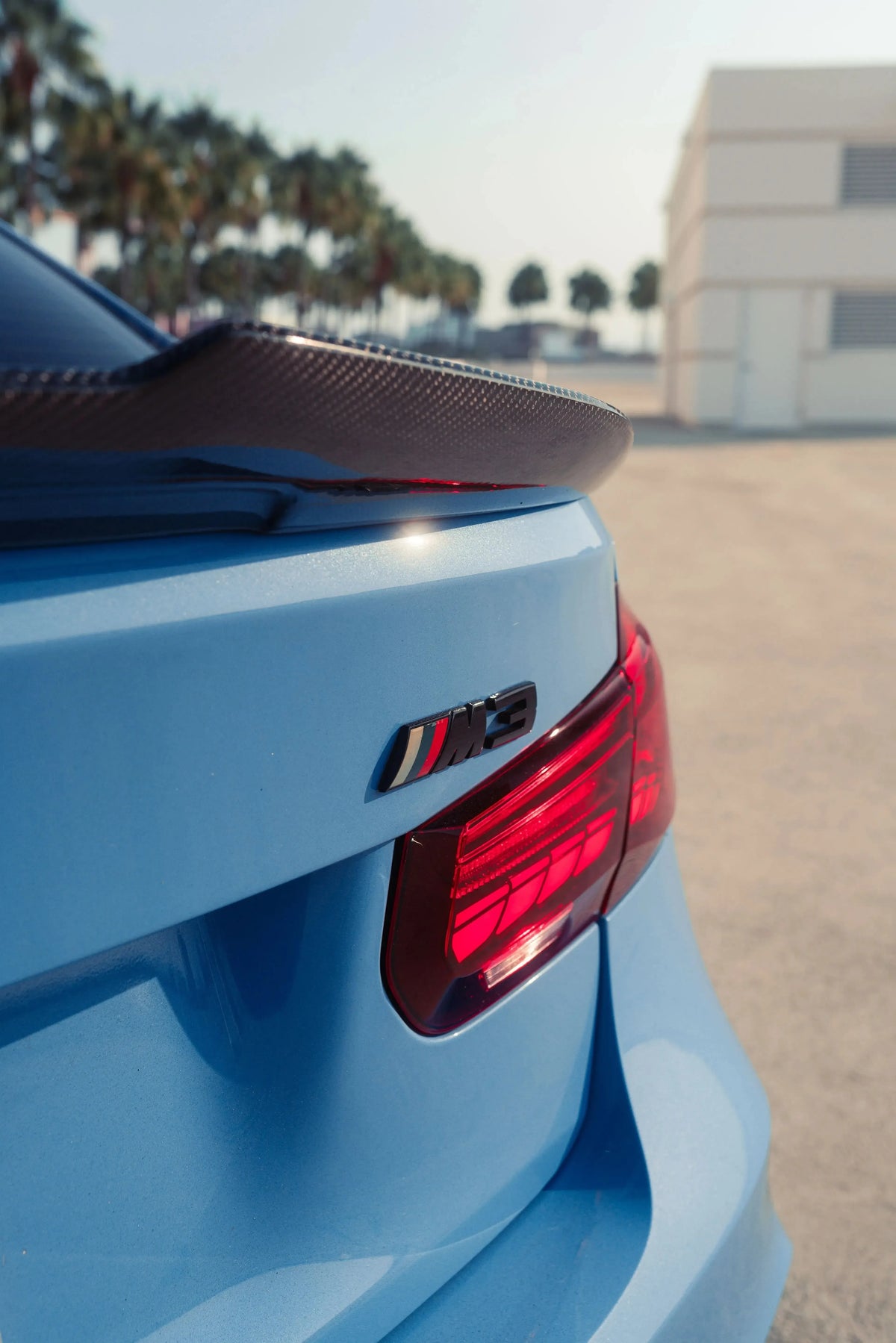 Red sequential OLED tail light on the rear corner of a blue BMW F80 M3, close-up (GTS Style)