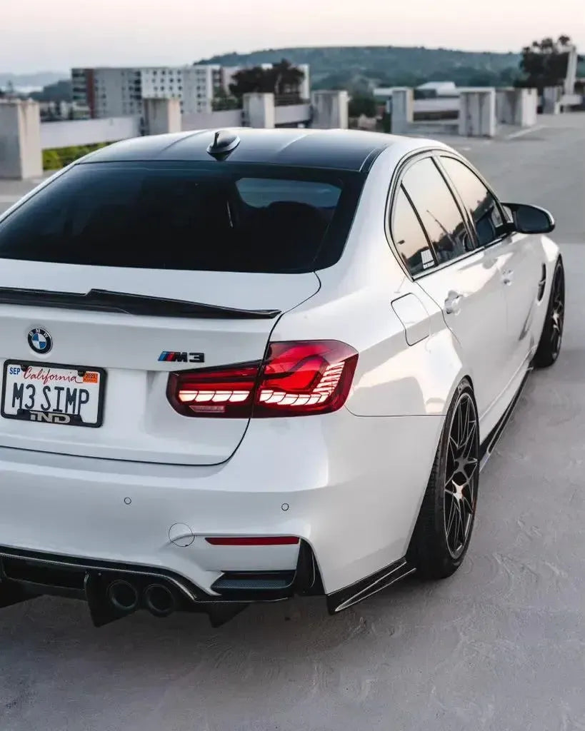 Illuminated red OLED tail lights on a white BMW F80 M3, three-quarter view from above (GTS Style)